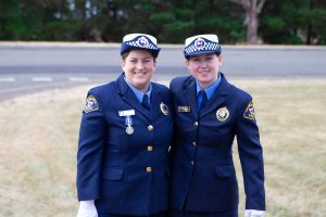 Two smiling police officers at graduation ceremony